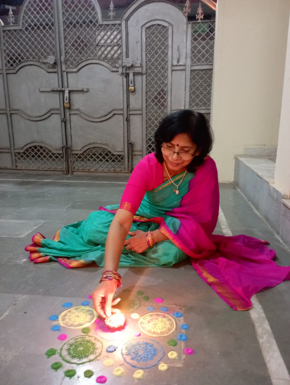 Padmaja Gupta making rangoli and lighting diyas